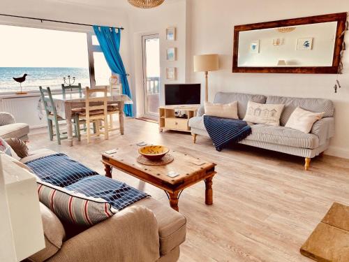 a living room with a couch and a table at 3 The Moorings, East Wittering in East Wittering