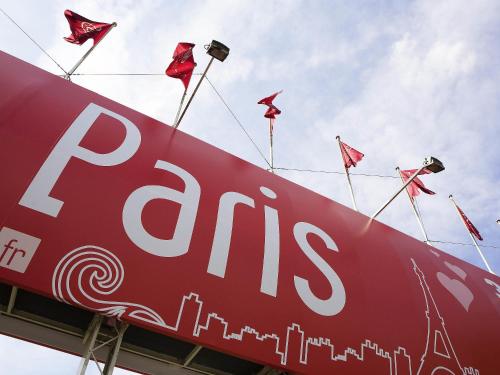 a sign with red flags on top of a building at Mercure Paris Le Bourget Aeroport in Le Blanc-Mesnil