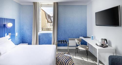 a hotel room with blue walls and a bed and a desk at Best Western Poitiers Centre Le Grand Hôtel in Poitiers