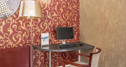 a desk with a computer on it in a room at Best Western Poitiers Centre Le Grand Hôtel in Poitiers