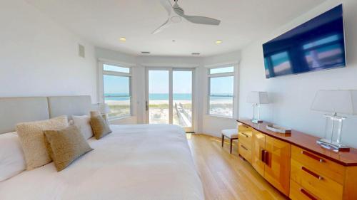 a bedroom with a large white bed with a view of the ocean at Spectacular 8 Bedroom Oceanfront Hamptons Beach House, Your Castle By The Sea ! in Remsenburg