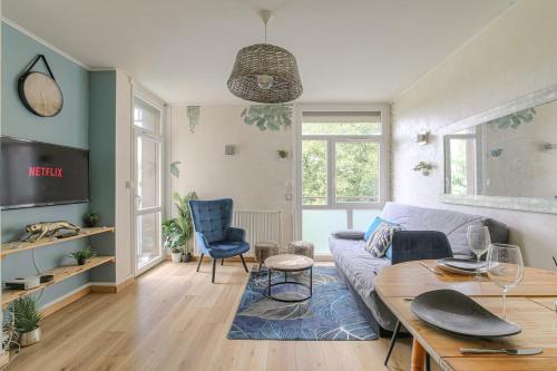 a living room with a couch and a table at Appartement 2 Chambres - Le Tropical in Oullins