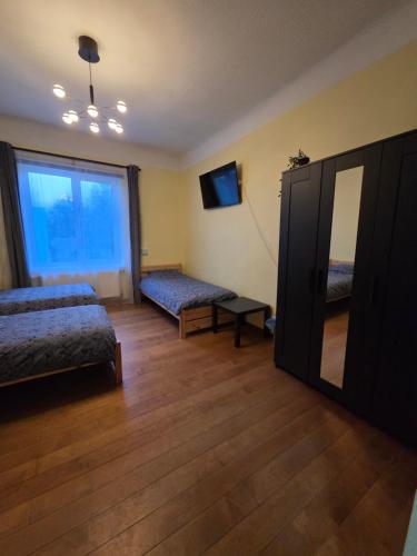 a bedroom with two beds and a large mirror at Pie Parka in Alūksne