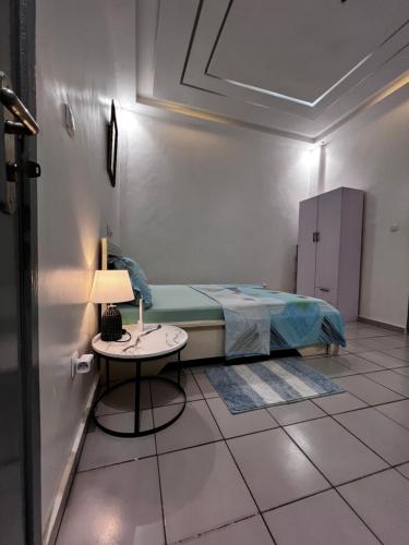 a bedroom with a bed and a table with a lamp at Les Résidences de Cobat in Kika