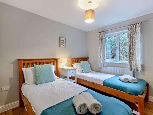 a bedroom with two beds and a window at 5 Bed in Witherslack SZ593 in Levens