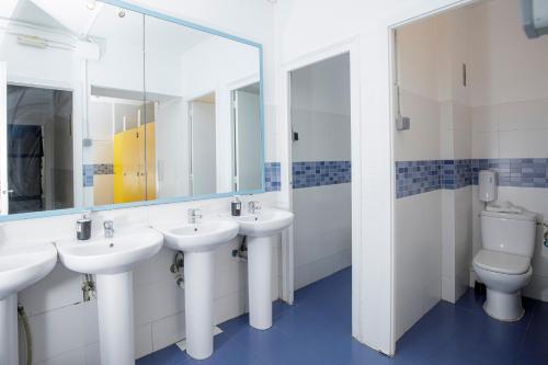 a bathroom with two sinks and a toilet at Onefam Les Corts in Barcelona