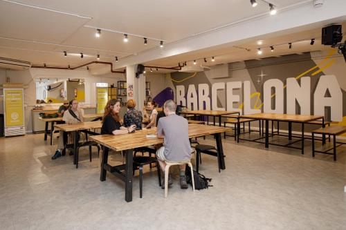 a group of people sitting at tables in a restaurant at Onefam Les Corts in Barcelona