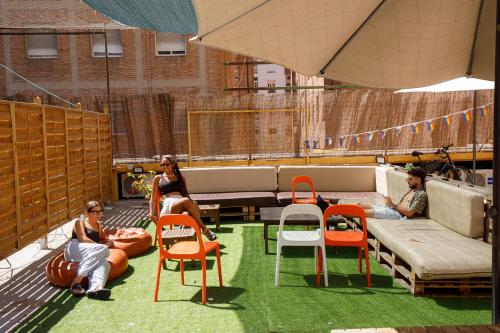 a group of people sitting in chairs on a patio at Onefam Les Corts in Barcelona