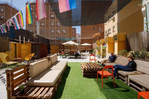 two people sitting on benches on a rooftop patio at Onefam Les Corts in Barcelona