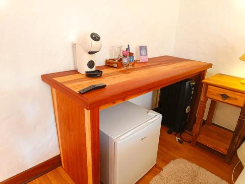 a wooden desk with a computer on top of a refrigerator at Pousada Hortelã in Campos do Jordão
