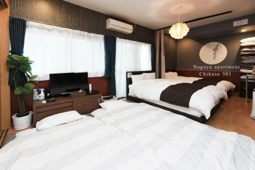 1 dormitorio con 2 camas y TV en Prosper 5, 5th floor, 501 - Vacation STAY 73075v, en Nagoya