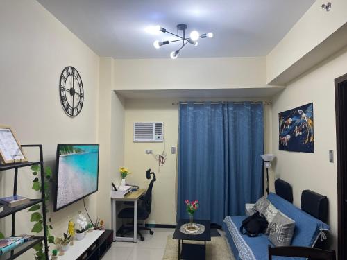 a living room with a blue couch and a tv at 1BR Condotel in Pasay Manila Near NAIA Airport, Mall of Asia, Manila Bay, PICC and CPP Pet-Friendly with Pool, Fast WiFi, Netflix in Manila