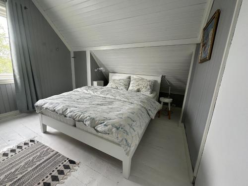 a bedroom with a bed in a white room at Koselig hus med stor og solrik hage in Lillehammer