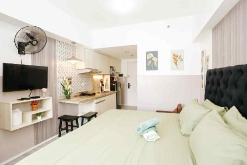 a living room with a bed and a kitchen at Sky's Cozy Nest in Cebu City