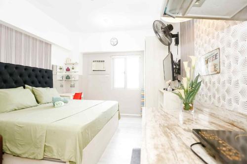 a white bedroom with a large bed and a couch at Sky's Cozy Nest in Cebu City