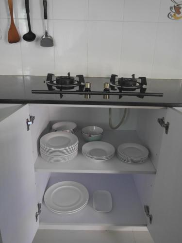 a kitchen with white plates and utensils on a shelf at Villa family in Ban Saiyuan (1)