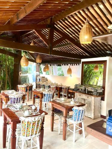 a restaurant with wooden tables and chairs and a television at Pousada Tartaruga Boutique Hotel in Pipa