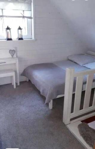 a bedroom with a bed and a desk and a window at Kameralny domek in Borsk