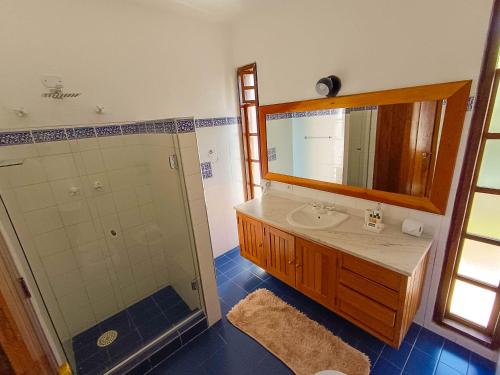 a bathroom with a sink and a shower and a mirror at Pousada Hortelã in Campos do Jordão