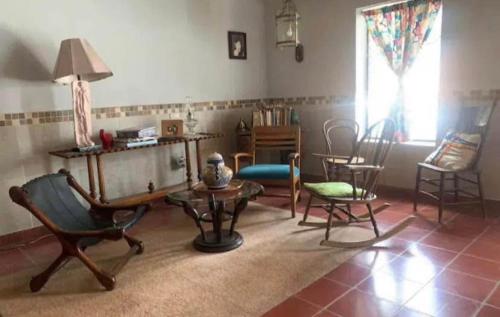 een woonkamer met stoelen en een tafel en een raam bij Habitación in Morelia