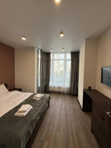 a bedroom with a bed with two towels on it at Апартаменти ВІП вул Під Голоском 15 б 9-1 in Lviv