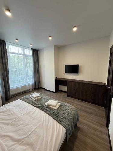 a bedroom with a large bed and a flat screen tv at Апартаменти ВІП вул Під Голоском 15 б 9-1 in Lviv