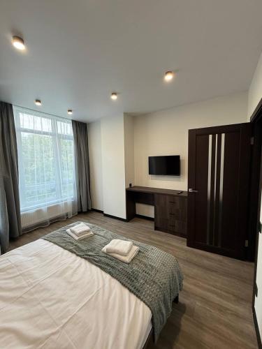 a bedroom with a large bed and a flat screen tv at Апартаменти ВІП вул Під Голоском 15 б 9-1 in Lviv