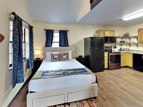 a bedroom with a large bed and a kitchen at SabaiDii Guesthouse B in Rockport