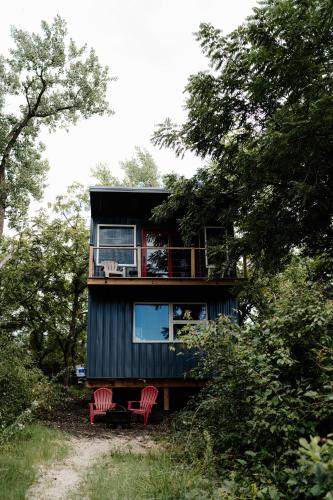 a house with two red chairs in the woods at Sonlit Retreats in Skyline