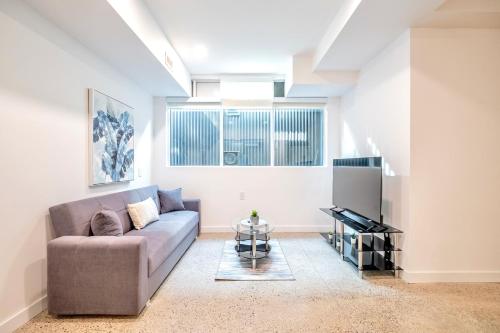 a living room with a couch and a piano at Inviting 2BR Basement Suite in Downtown Toronto - The Roland in Toronto
