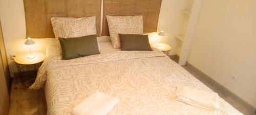 a bedroom with a large white bed with two lamps at Charmante maison familiale proche Bordeaux in Floirac