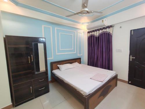 a bedroom with a bed and a cabinet and a tv at SN3 Hotel in Fatehpur City