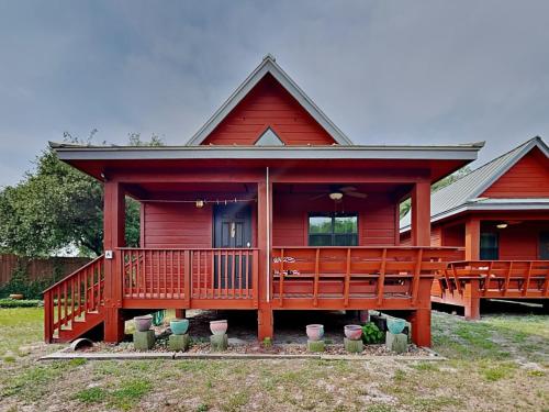 Una gran casa roja con una gran terraza. en SabaiDii Guesthouse A, en Rockport
