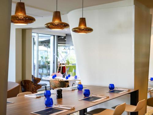 a dining room with a table with blue vases on it at Hotel Novotel Evry Courcouronnes in Evry-Courcouronnes