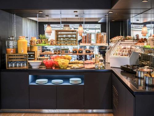 a buffet line with food on display in a restaurant at Hotel Novotel Evry Courcouronnes in Evry-Courcouronnes