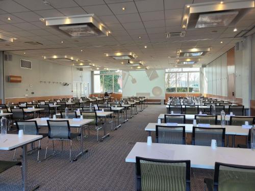 an empty classroom with tables and chairs in it at Hotel Novotel Evry Courcouronnes in Evry-Courcouronnes