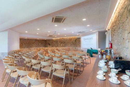 a room with rows of chairs and a stage with a screen at Mangia's Brucoli, Sicily, Autograph Collection in Brucoli