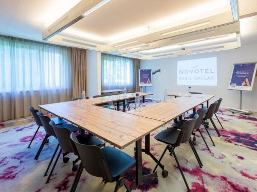 a large conference room with a long table and chairs at Novotel Saclay in Saclay