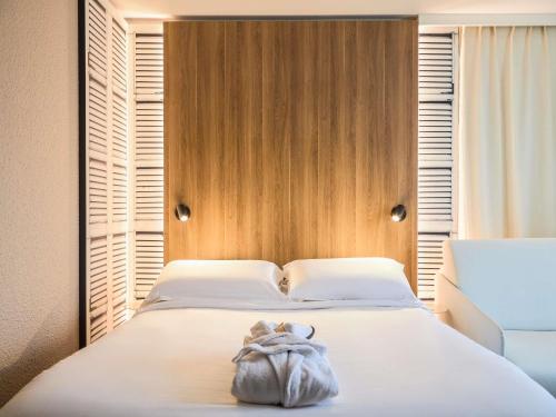 a bedroom with a bed with a purse on it at Mercure Aix en Provence Beaumanoir in Aix-en-Provence