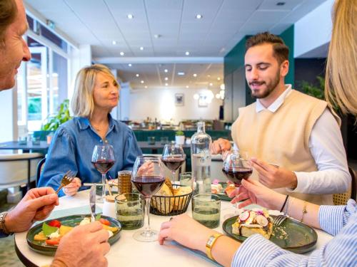 a group of people sitting around a table with wine glasses at Mercure Aix en Provence Beaumanoir in Aix-en-Provence