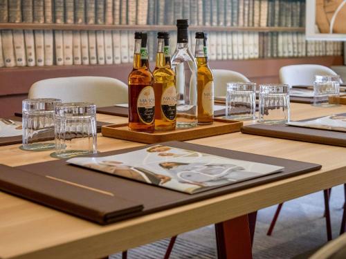 a table with bottles of wine and glasses on it at Mercure Aix en Provence Beaumanoir in Aix-en-Provence