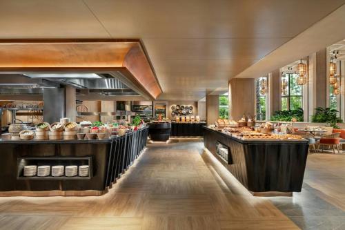 Un restaurante con una línea de buffet con comida. en Pattaya Marriott Resort and Spa, en Jomtien Beach