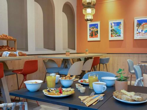 a table with plates of food on top at Novotel Aix-en-Provence Pont de L'Arc in Aix-en-Provence