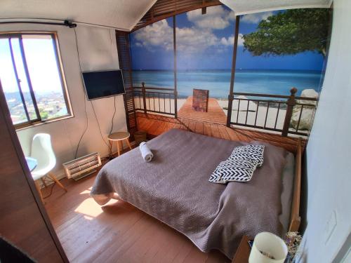 a bedroom with a bed and a view of the ocean at habitación con vista al mar Altavista Hostal in Valparaíso