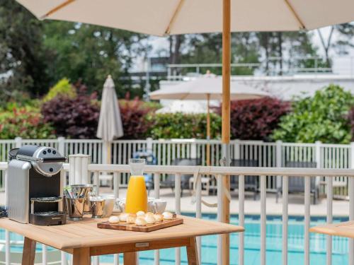 a table with a coffee maker and a drink on it at Novotel Bordeaux Mérignac in Mérignac
