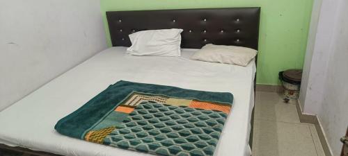 a bed with a blanket on it in a room at Hotel V L in Lucknow