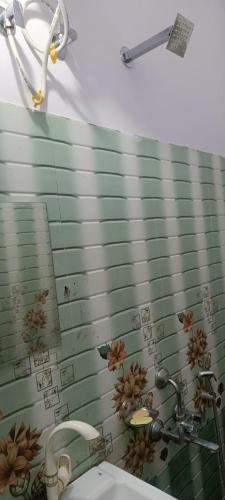a bathroom with a sink and flowers on the wall at Hotel V L in Lucknow