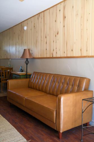 a brown leather couch sitting in a living room at Rocky Mountain Inn in Paonia