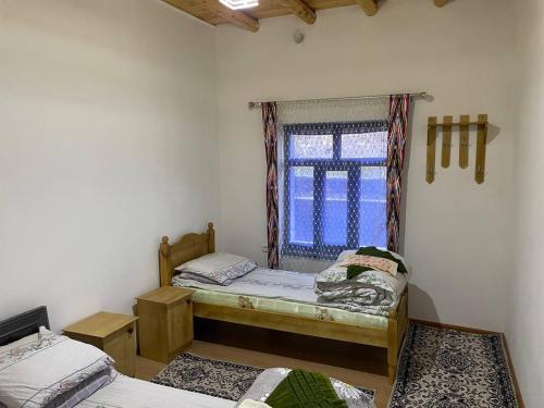 een kamer met twee bedden en een raam bij Firdavs guest house in Yukary-Ukhum