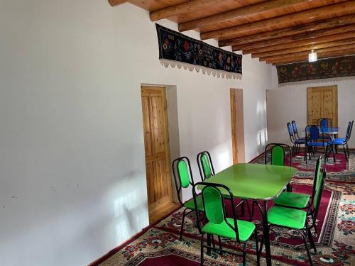 a dining room with a green table and chairs at Firdavs guest house in Yukary-Ukhum